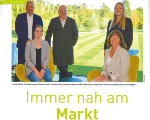 Gruppenfoto von fünf Personen im Freien; darunter steht „Immer nah am Markt“.